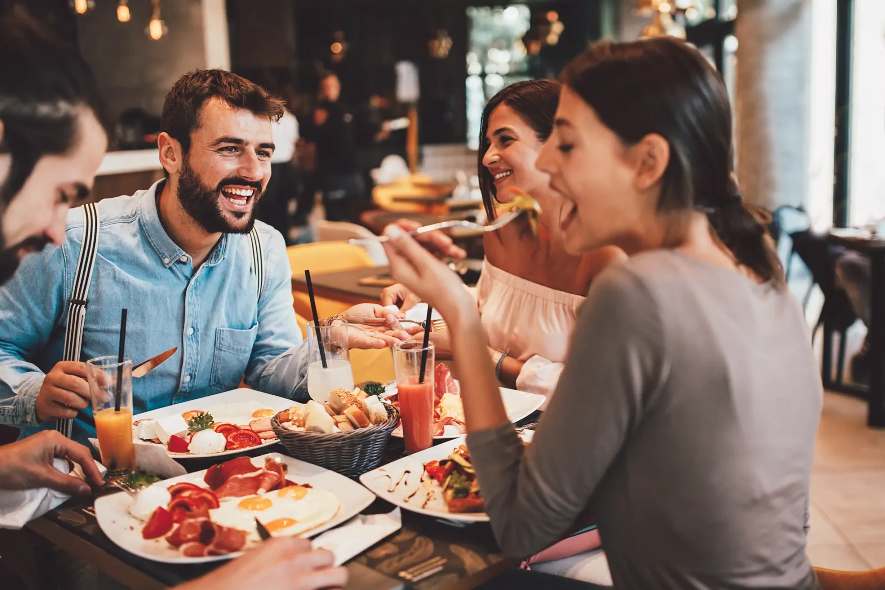 Friends eating and laughing at a nice restaurant.