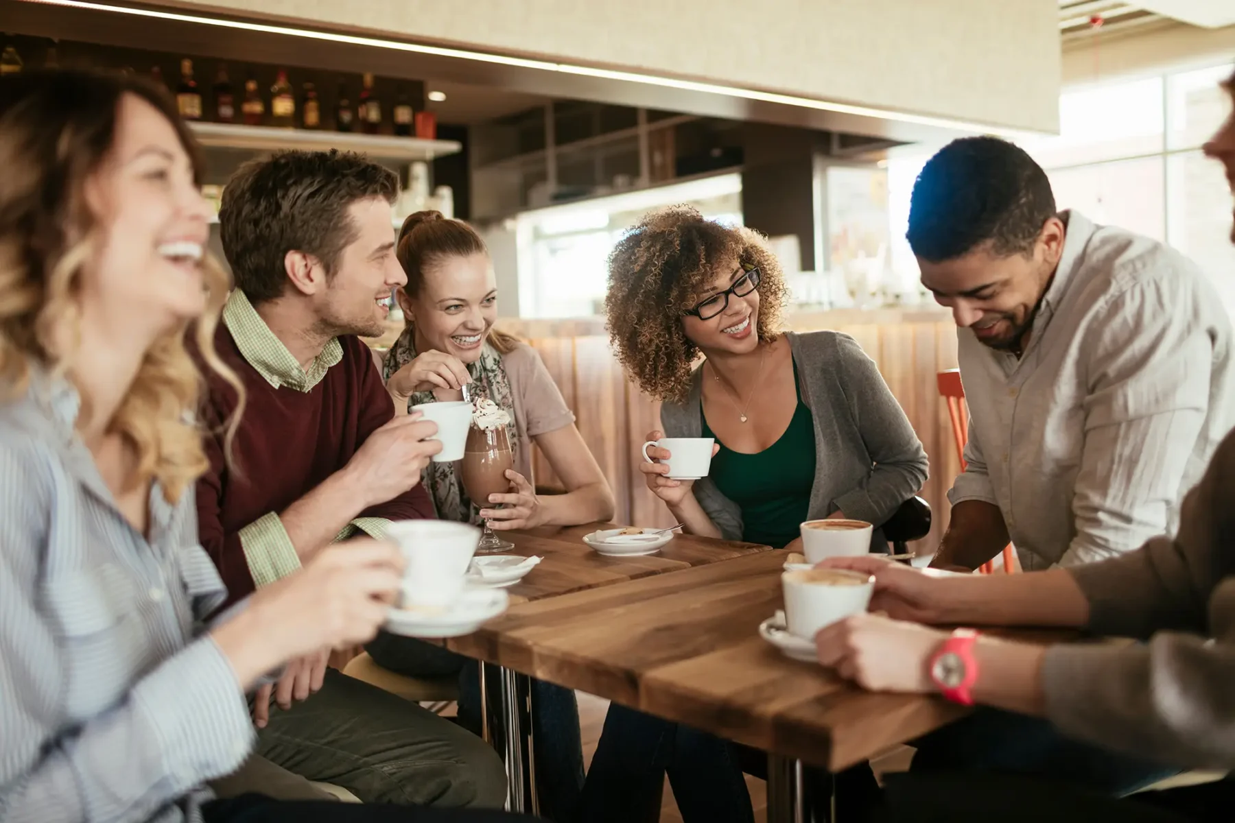 Friends at an outdoor dinner clinking glasses together for a toast