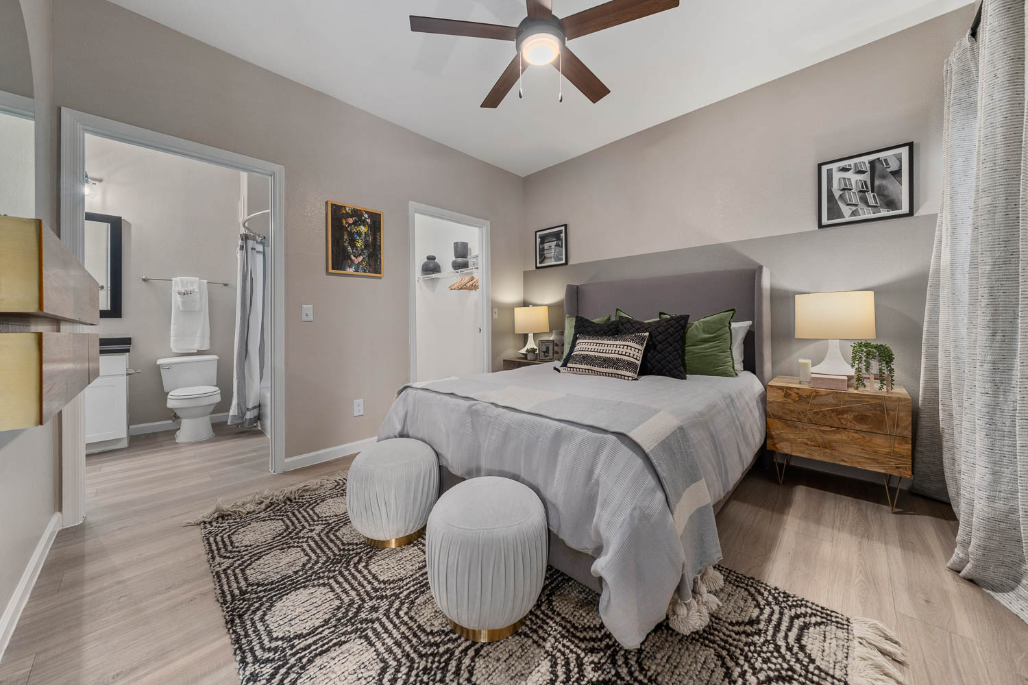 Bedroom with ceiling fan, private bath, and walk in closet