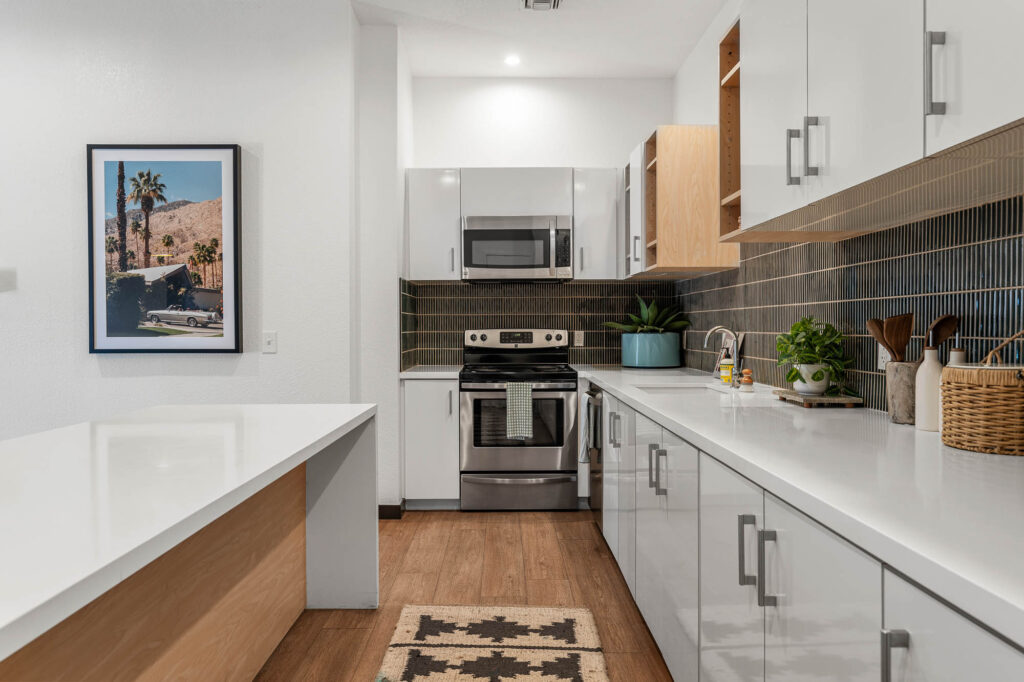 Clubhouse kitchen with oven, microwave, and white countertops and cabinets.